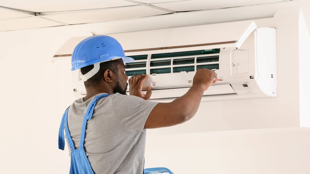 AC repair in Smyrna, GA: Technician repairs an air conditioning unit. Signs your AC needs immediate repair in Atlanta, GA.