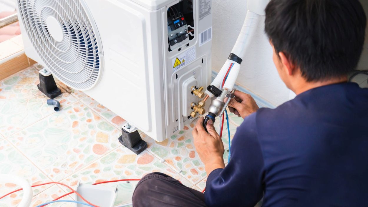 AC repair in Smyrna, GA: Technician repairs an AC unit. Prompt attention can prevent extensive damage. Signs your AC needs repair.