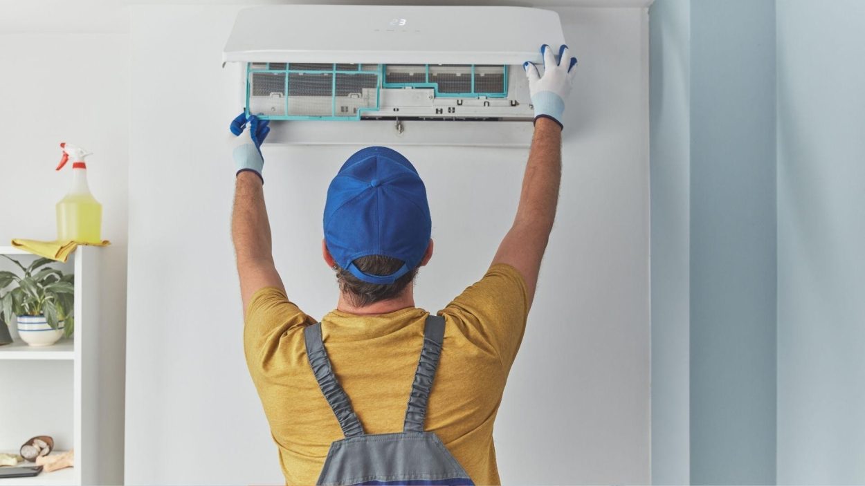 24/7 AC repair: Technician in Atlanta, GA, servicing an air conditioner unit. Expert maintenance for emergency HVAC issues.