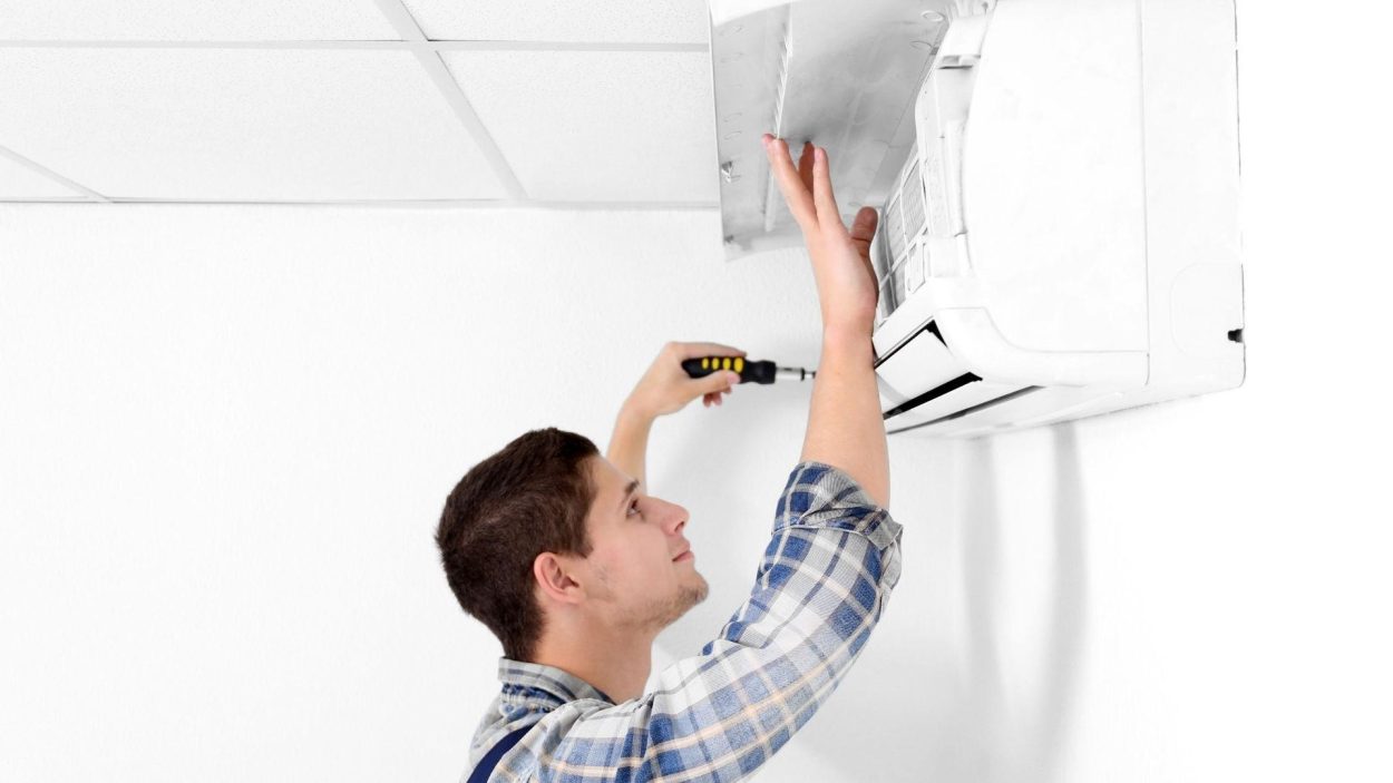 AC repair: Technician repairing an air conditioner. Common signs your AC needs repair in Atlanta, GA right away. AC service.