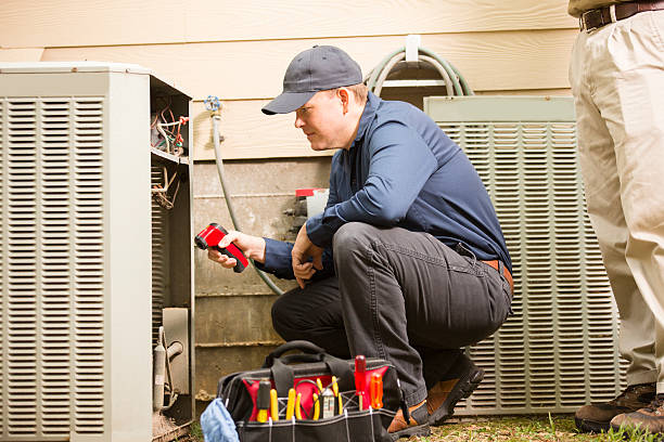 HVAC technician inspecting heat pump, emergency heating repair in Atlanta.
