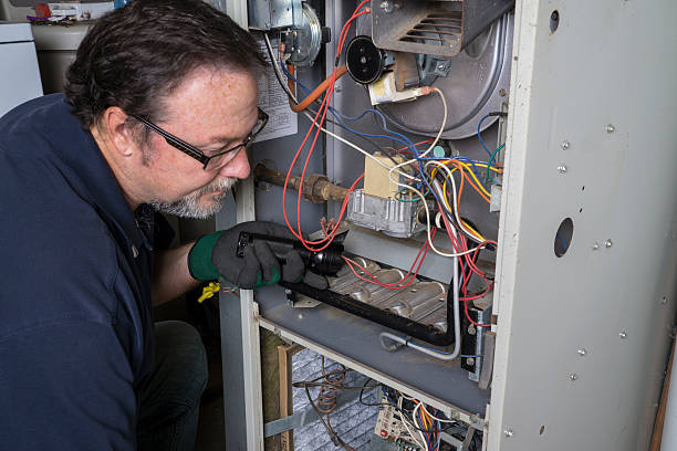 HVAC technician inspecting furnace components for residential repair in College Park, GA.