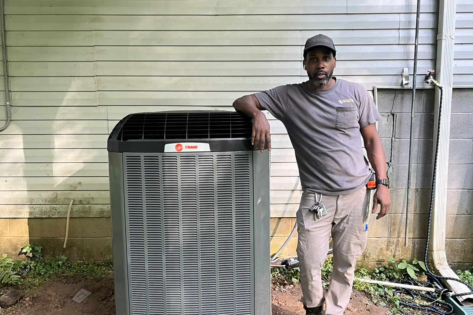 An Indoor Experts technician beside an outdoor Trane air conditioning condenser in Atlanta