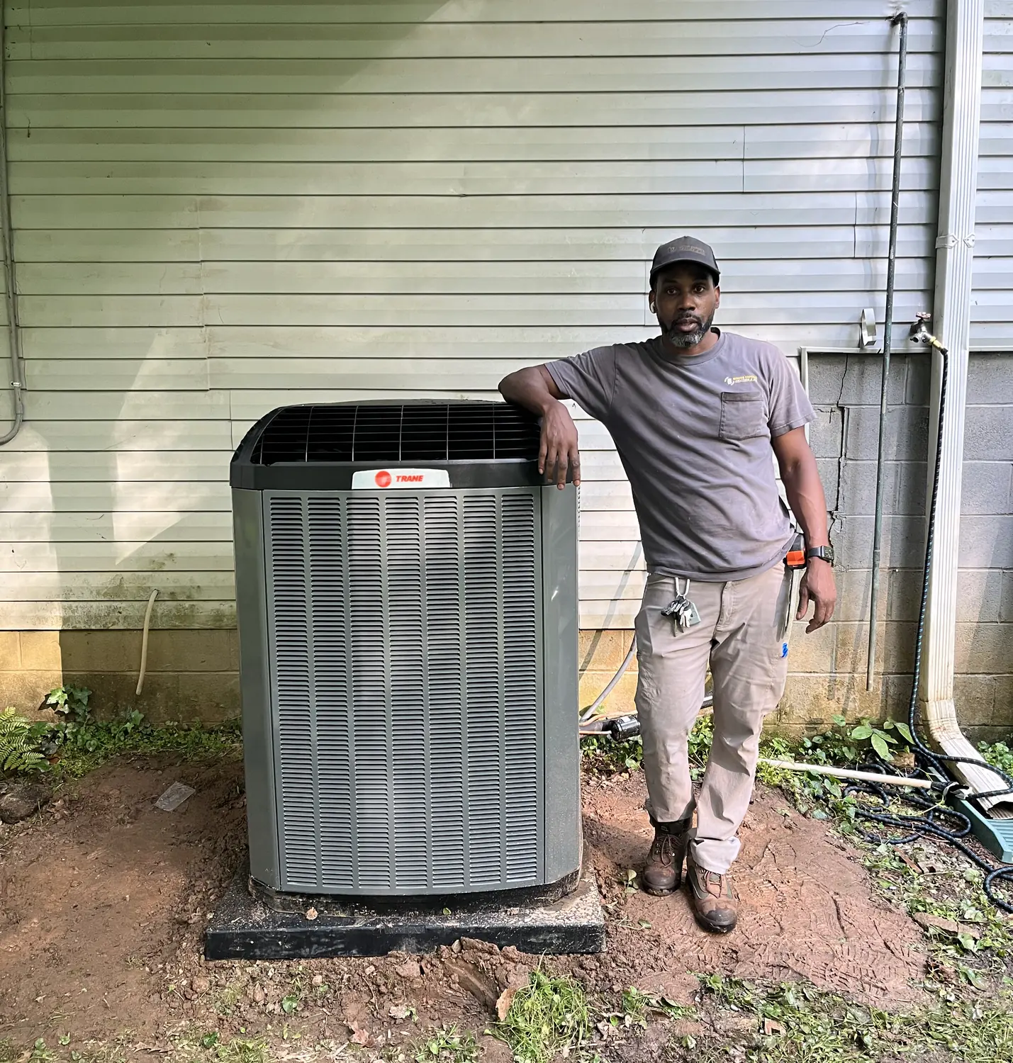An Indoor Experts technician servicing an air conditioner condenser in Atlanta